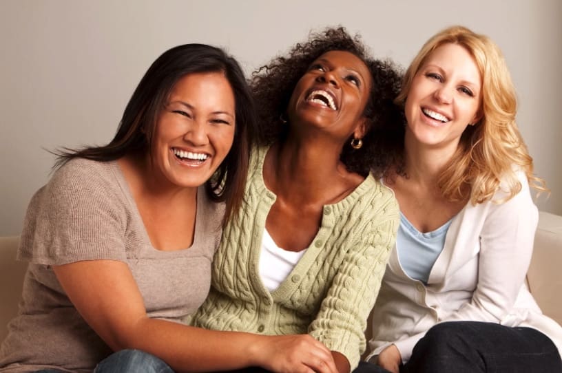 Christian healing retreat. Three women laughing together.