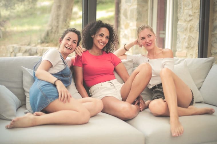 Three women laughing together during an arKardia healing retreat for women, sharing connection in a small-group setting.