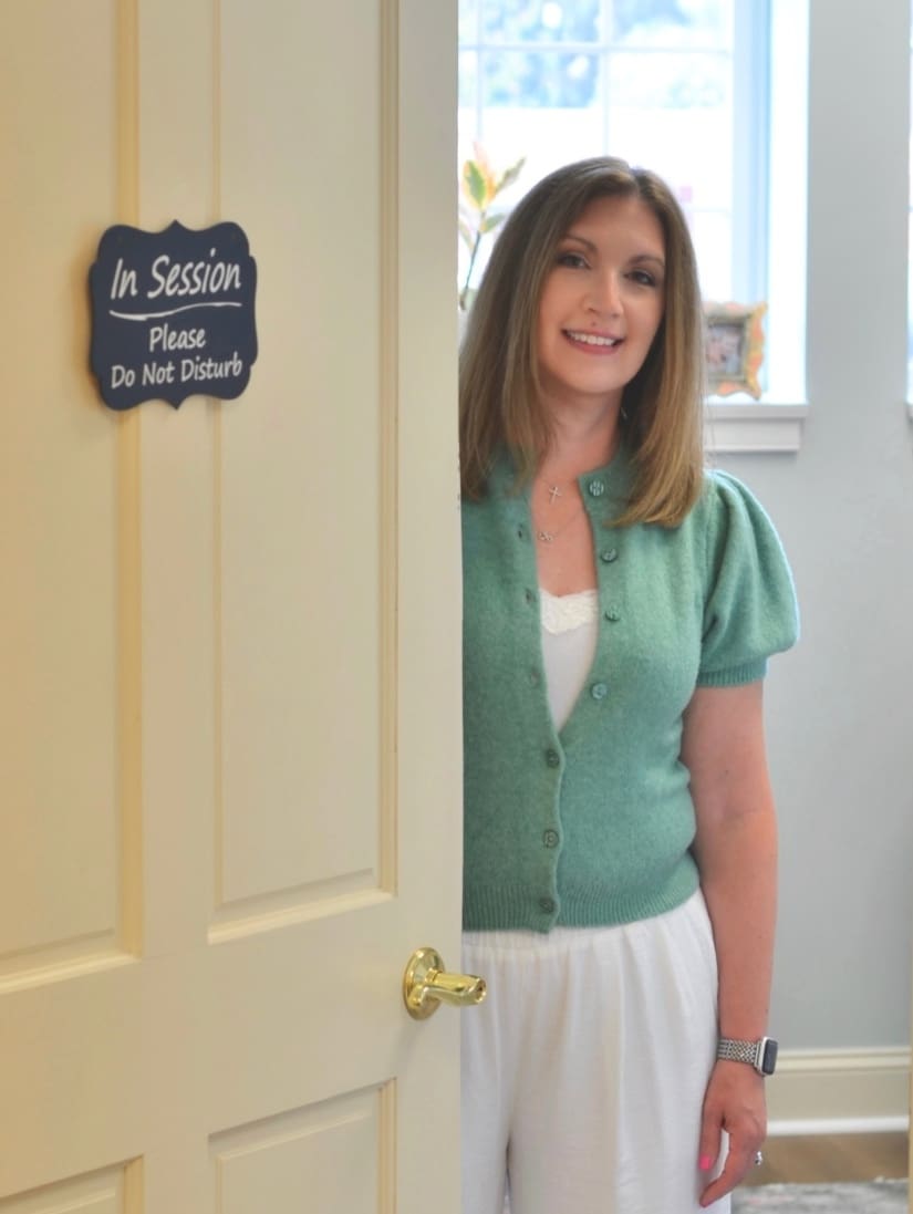 Michele Montenegro, private pay therapist, standing beside her "In Session" office door in Gettysburg, PA.