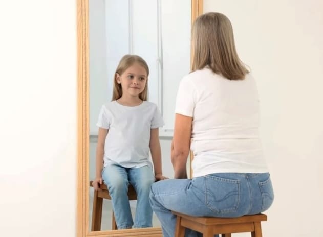Mother and daughter in a mirror exercise during a therapy session, illustrating the relational, body-aware approach private pay therapist Michele Montenegro brings to her practice.