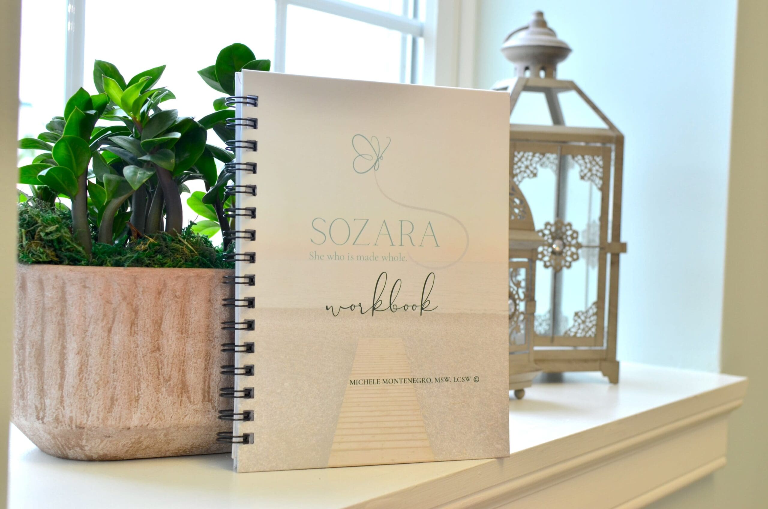 Sozara healing retreat workbook styled with lanterns and greenery, part of the materials provided at arKardia's healing retreats.